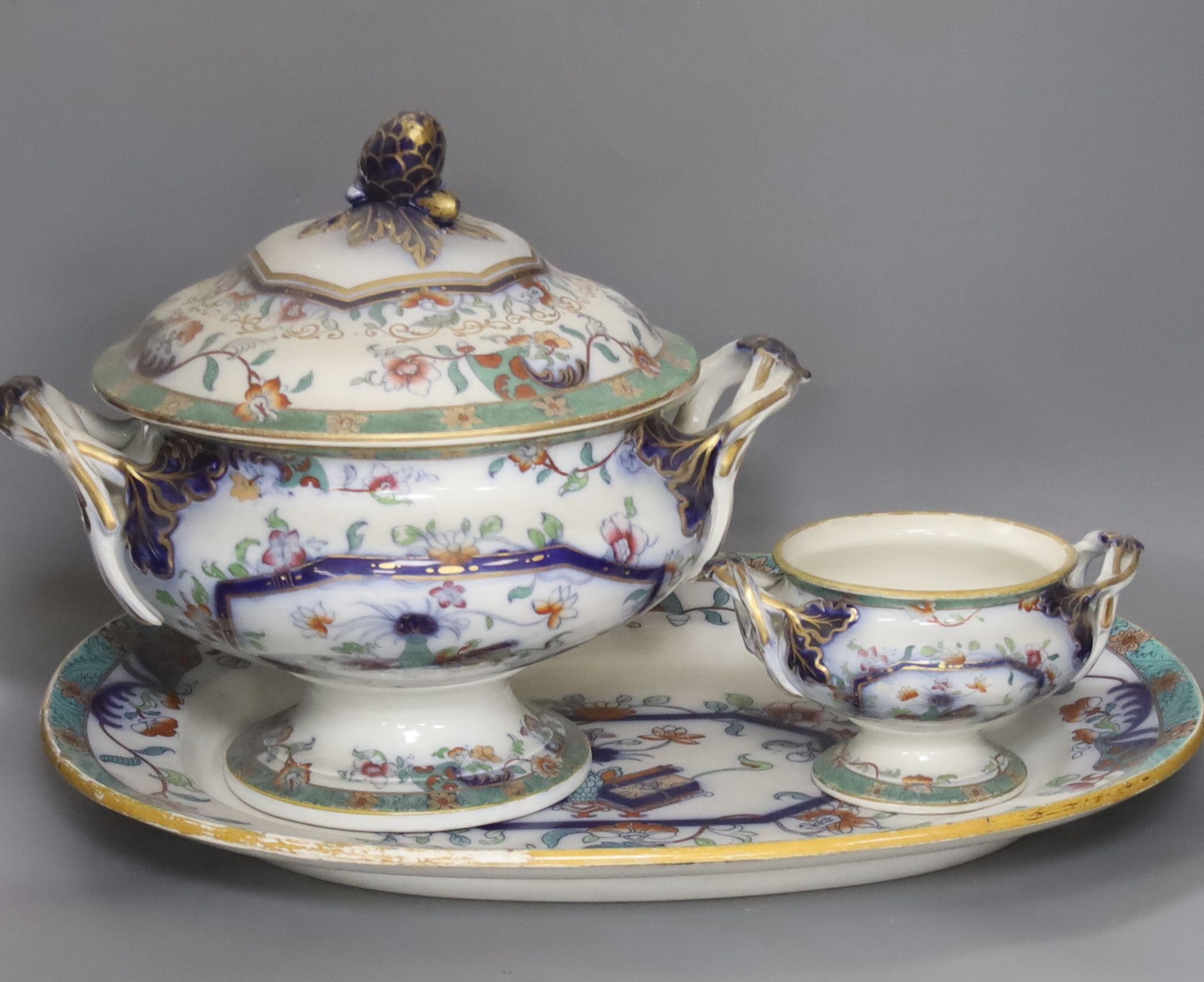 A mid 19th century Staffordshire pottery lidded soup tureen and cover (base cracked), a large meat dish and a sauce tureen (lacking lid) (3)